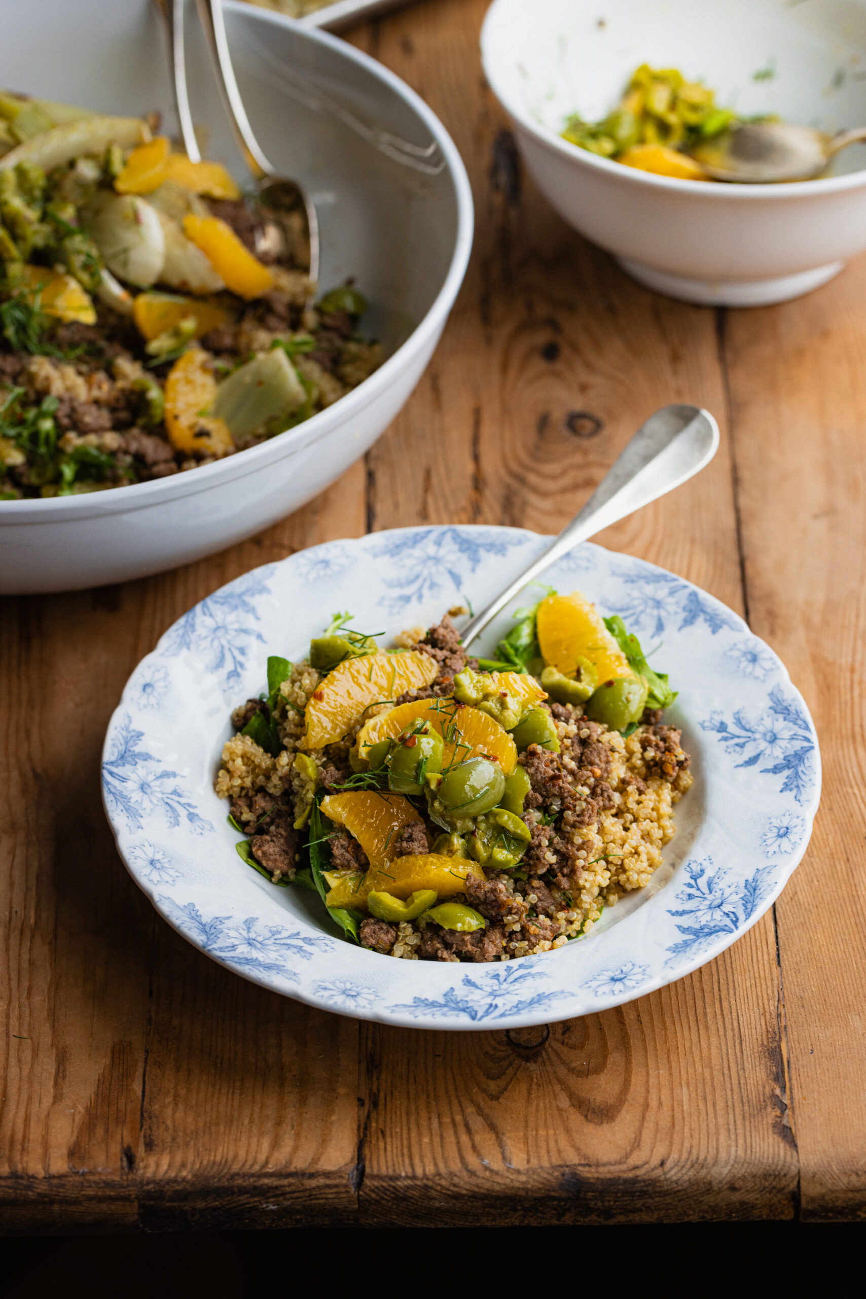 Hearty, Healthy Fennel, Orange & Olive Ground Lamb Quinoa Bowls on a tabletop.